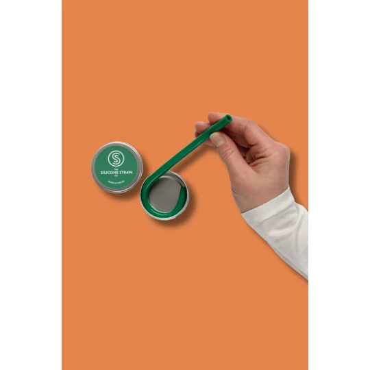 a hand removing a green silicone straw from a travel tin