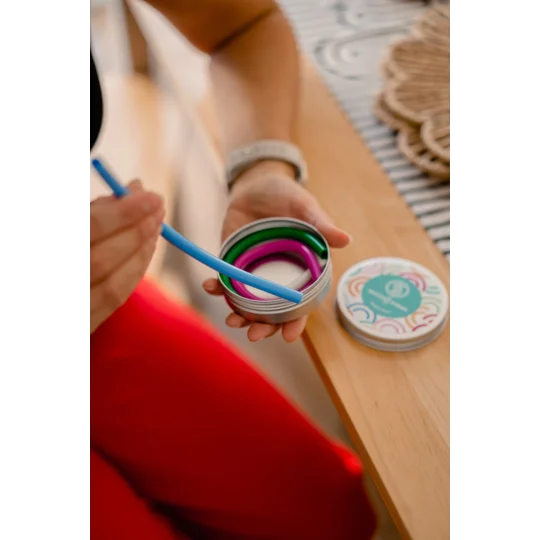 Adult removing a silicone straw from a holder ready to use in a drink