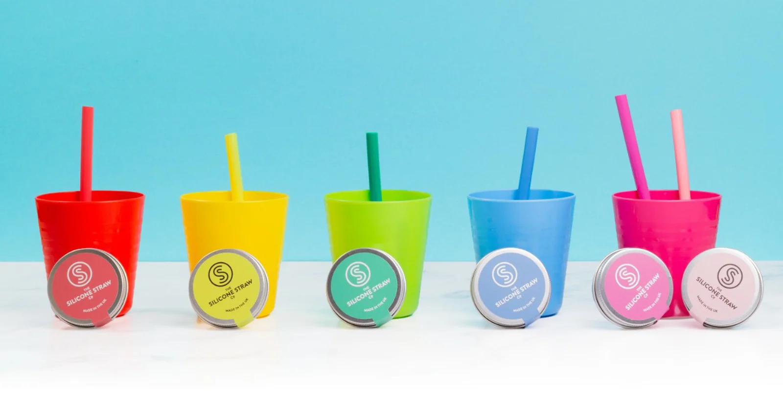 Colourful cups with silicone straws, each with its travel tin
