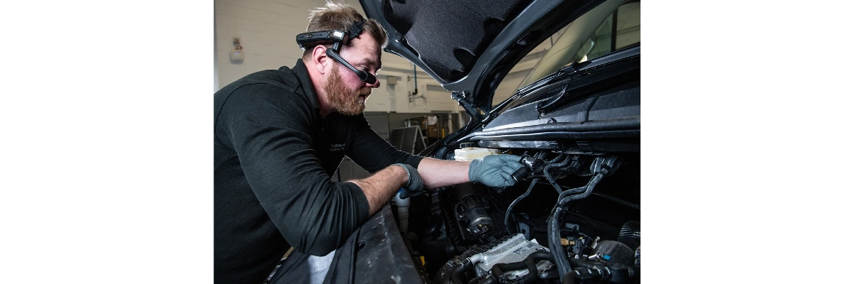A photo of an automotive engineer at work and wearing a realwear headset