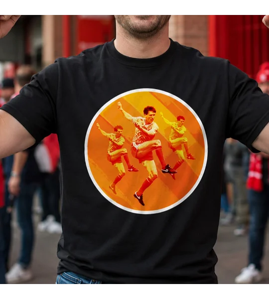Black football T-shirt featuring a bold orange and yellow retro football player graphic, modelled by a fan outside a stadium