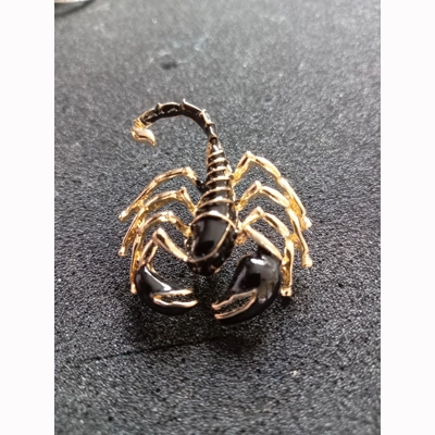 Black and gold coloured scorpion pin brooch