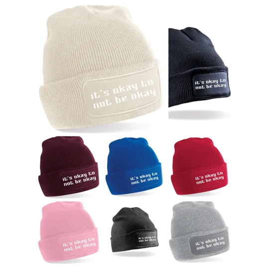 various coloured beanies with it's okay to not be okay printed in white text, beanies colours of blue, navy, black, light grey, burgendy red, almond, red, and pink