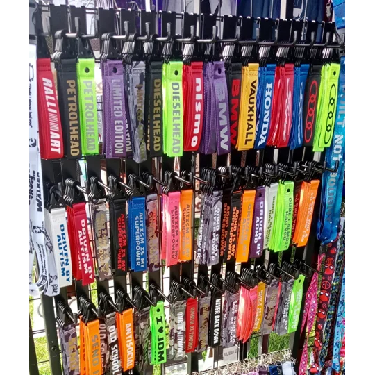 a close up angle photo of qmruk autoworx variety of printed mini lanyards (keyclips) in various colours and prints. these are for adhd and autism awareness, such as autism is my superpower, driven by autism, driven by adhd and adhd is my superpower