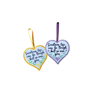 Two felt heart keepsakes hanging on ribbons, embroidered with the words “Sometimes life can be tough but so are you”, shown in two colour designs.