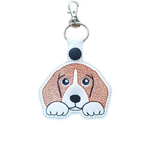 Kawaii beagle dog keyring made from white faux leather with brown embroidered ears, bright eyes, paws, black nose, keyring and lobster clasp.