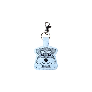 A kawaii-style bearded schnauzer dog keyring with a grey embroidered face, bushy eyebrows, and paws-up pose, shown on a plain white background.