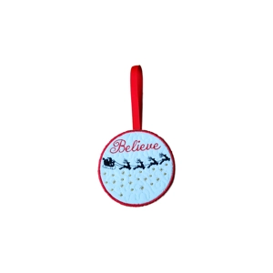 Round felt Christmas ornament embroidered with the word ‘Believe’ above Santa’s sleigh and reindeer, finished with a red ribbon loop for hanging.