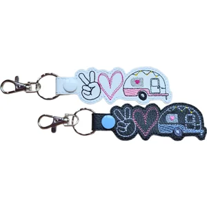 Black and white Caravan Peace Love faux leather keyrings with embroidered peace sign, heart and caravan design.