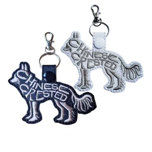 Black and white Chinese Crested word art keyrings with embroidered details, shown with metal keyrings and clasps.