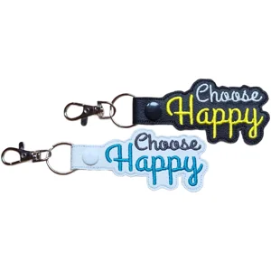 Black and white faux leather Choose Happy keyrings with colourful embroidered lettering and sturdy metal keyring clips.