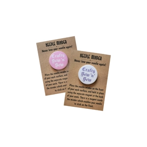 Two round magnetic needle minders on kraft instruction cards, one with a pink background and one with a white background, both featuring the words “Crafty Sew ’n’ Sew” in contrasting text.