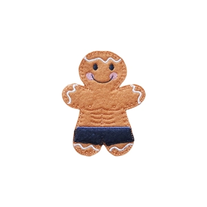 A gingerbread bodybuilder character made from felt, with a smiling face, stitched six-pack, flexed arms, white icing-style details, and black shorts.