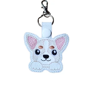 Cute chihuahua dog keyring made from white faux leather with pink ears, beige stitched details, bright embroidered eyes, keyring and lobster clasp.