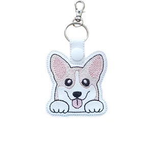 Cute corgi dog keyring made from white faux leather with big ears, pink stitched details, bright embroidered eyes, tongue-out smile, keyring and lobster clasp.