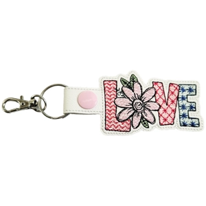 A faux leather floral love keyring featuring the word ‘Love’, with the ‘O’ replaced by a stitched flower, finished with a metal keyring and lobster clasp.