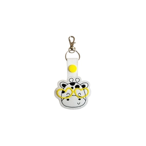 A faux leather keyring featuring an embroidered giraffe face wearing yellow heart-shaped glasses, attached to a silver keyring clip.