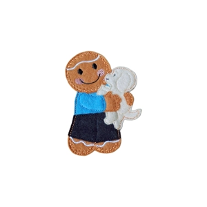 Gingerbread Puppy Love Character – a handmade felt gingerbread holding a small cream puppy, dressed in a blue top and black trousers, with embroidered details and a stitched smile.