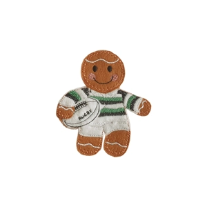 A handmade felt gingerbread rugby player character with embroidered details, wearing a white and green striped rugby kit and holding a stitched rugby ball. The character has a smiling face with rosy cheeks and decorative icing-style stitching on the arms and legs.