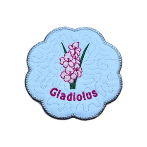 Embroidered August Gladiolus birth flower candle coaster with pink flower, green leaves, scalloped border, and pink Gladiolus text.