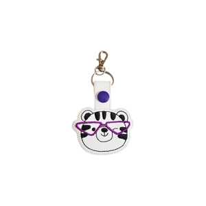 An embroidered tiger keyring with a smiling tiger face wearing purple glasses, finished with a silver keyring and lobster clasp.