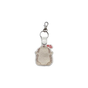 A white faux leather hedgehog keyring shown from the back, with brown embroidered quills, two small red hearts near its ear, and a metal keyring and clasp at the top.