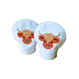 Pair of felt tealight covers featuring embroidered Highland cow designs, shaped to sit over LED tealights.