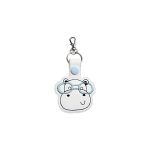 Embroidered hippo keyring with cute stitched glasses, attached to a white tab with a light blue snap fastener and a metal keyring and clasp.