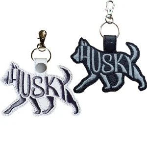 Two Husky word art dog keyrings in black and white faux leather, with embroidered breed designs and metal clasp fittings.