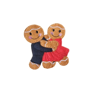 A felt gingerbread couple posed in a ballroom dance hold, with one wearing a suit and the other a flowing dress, both with smiling faces and icing-style details.
