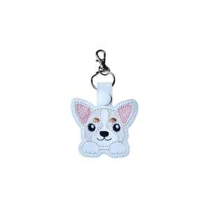 A white faux leather keyring featuring an embroidered kawaii-style Chihuahua with big twinkling eyes, large pink ears and tiny paws. The keyring is attached to a metal ring and lobster clasp.