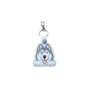 Kawaii-style embroidered Husky keyring featuring a smiling Husky face with bright eyes, fluffy ears and a tongue-out expression, attached to a white faux leather strap with a metal ring and lobster clasp.