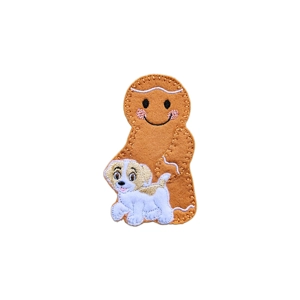 A gingerbread character holding a small embroidered dog, stitched in felt with a smiling face, rosy cheeks, and detailed dog features including floppy ears and a wagging tail.
