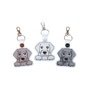 A kawaii-style Labrador dog keyring with a paws-up pose, shown in three designs representing Black, Chocolate, and Golden Labradors on a plain white background.
