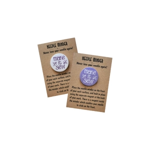 Make It Sew needle minder shown on kraft backing cards, featuring a round design with white text on a light purple background and purple text on a white background.