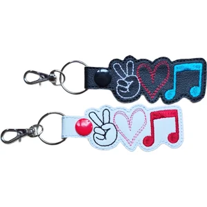 Black and white Music Peace Love keyrings featuring embroidered peace signs, hearts and music notes, finished with metal keyring hardware.