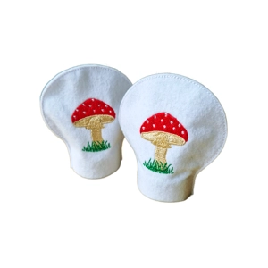 Two white felt LED tealight covers with embroidered red and cream toadstool designs, shown side by side.