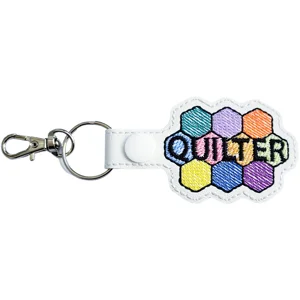 White faux leather Quilter keyring with colourful hexagon patchwork design and embroidered stitching detail spelling ‘Quilter’.