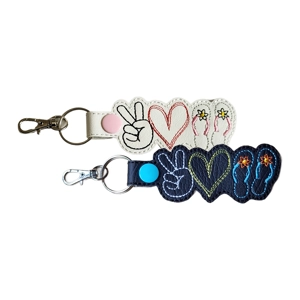 Embroidered peace sign, heart and flip flops keyring shown in black and white colourways.