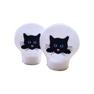 Two felt LED tealight covers with white felt backgrounds, each embroidered with a black cat peeking over the front, featuring bright blue eyes, whiskers, and a small pink heart-shaped nose.