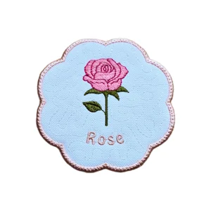 Embroidered June rose birth flower candle coaster with pink rose, green leaves, pale pink scalloped edging and Rose text.