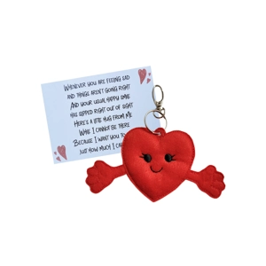A smiling red felt heart pocket hug with outstretched arms, slightly padded and machine embroidered, attached to a silver keyring clip and shown beside a printed keepsake card.