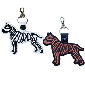 Staffordshire Terrier word art keyrings shown in white and black faux leather, with embroidered dog-shaped designs and silver keyring clasps.