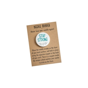 A round 38 mm needle minder with the words “Stay Strong”, finished with a small grey leaf motif, presented on a kraft backing card.