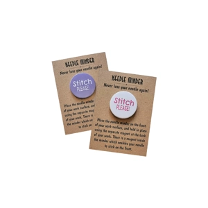 Two round 38 mm needle minders reading “Stitch Please”, one with white text on a light purple background and one with dark pink text on a white background, both presented on kraft backing cards.