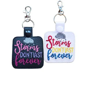 Black and white Storms Don’t Last Forever quote keyrings made from faux leather, with embroidered rain cloud details and colourful positive quote stitching.