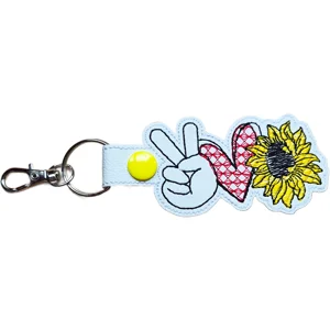 White Sunflower Peace Love keyring made from faux leather, featuring a peace sign hand, stitched heart and bright sunflower design with sturdy metal ring and lobster clasp.