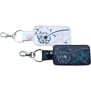 Black and white Wish Upon A Dandelion positive keyrings with embroidered dandelion designs, wish wording and metal clip hardware.