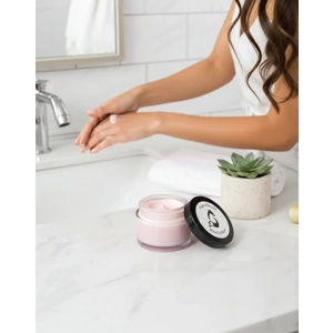 Woman applying pea sized amount of solid hand cream to cuticles