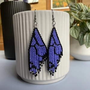 Unique earrings feature intricate beadwork, capturing the delicate charm of butterfly wings in vibrant purple